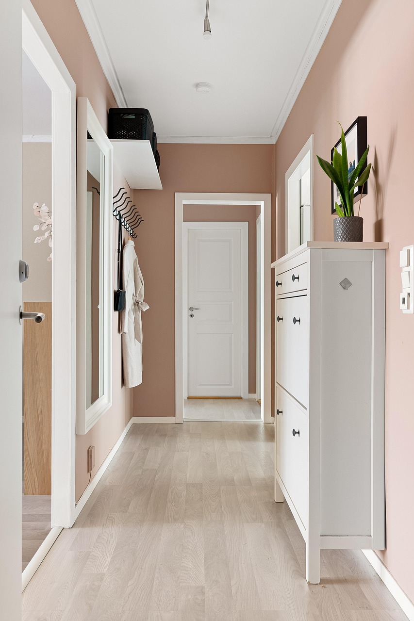 couloir d'entrée de maison décorée rose pale et blanche