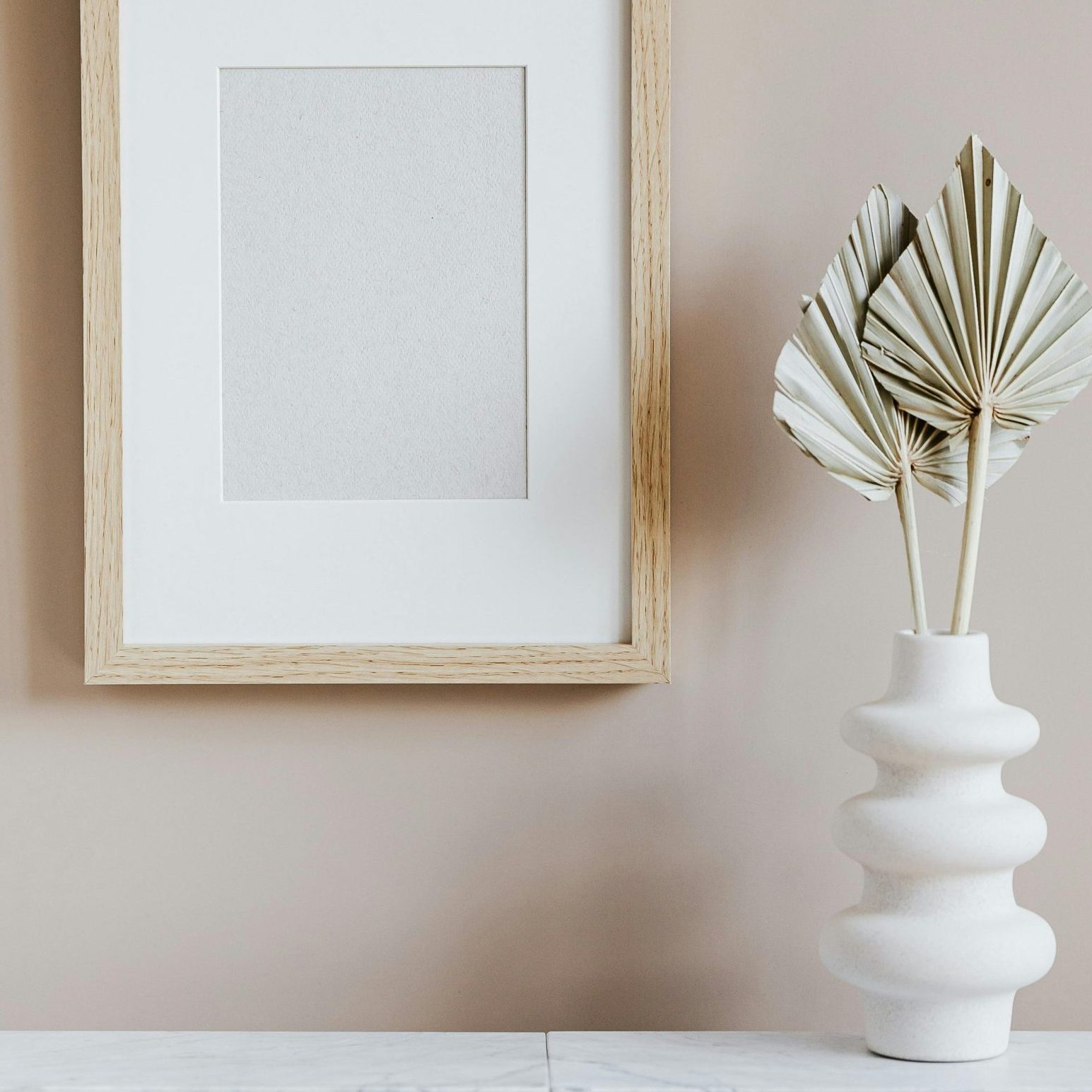 vase blanc et cadre enbois